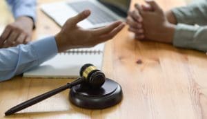 two people sitting at a table with a judge's gaven.