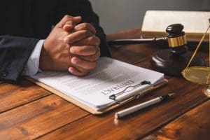 A lawyer in a suit sitting at a desk with a judge's gavel discussing criminal record consequences.