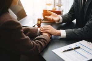 A businessman and woman shaking hands at a desk.